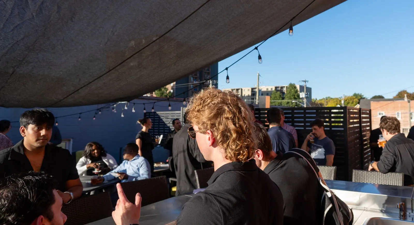 Rooftop networking event under string lights
