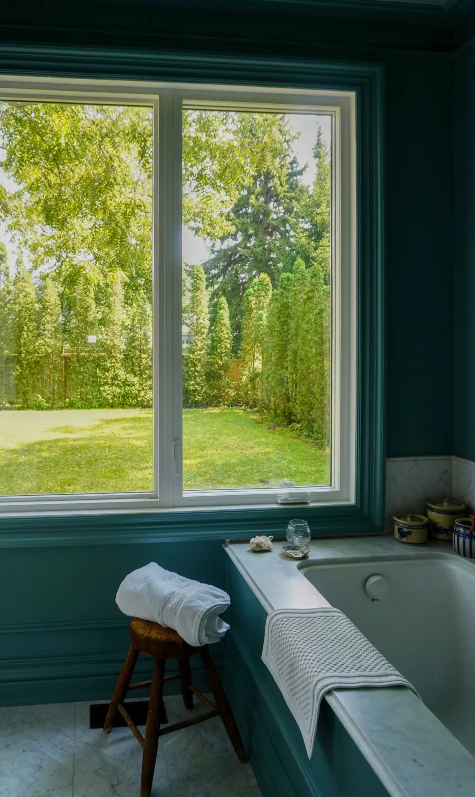 Teal bathroom with a window onto the garden