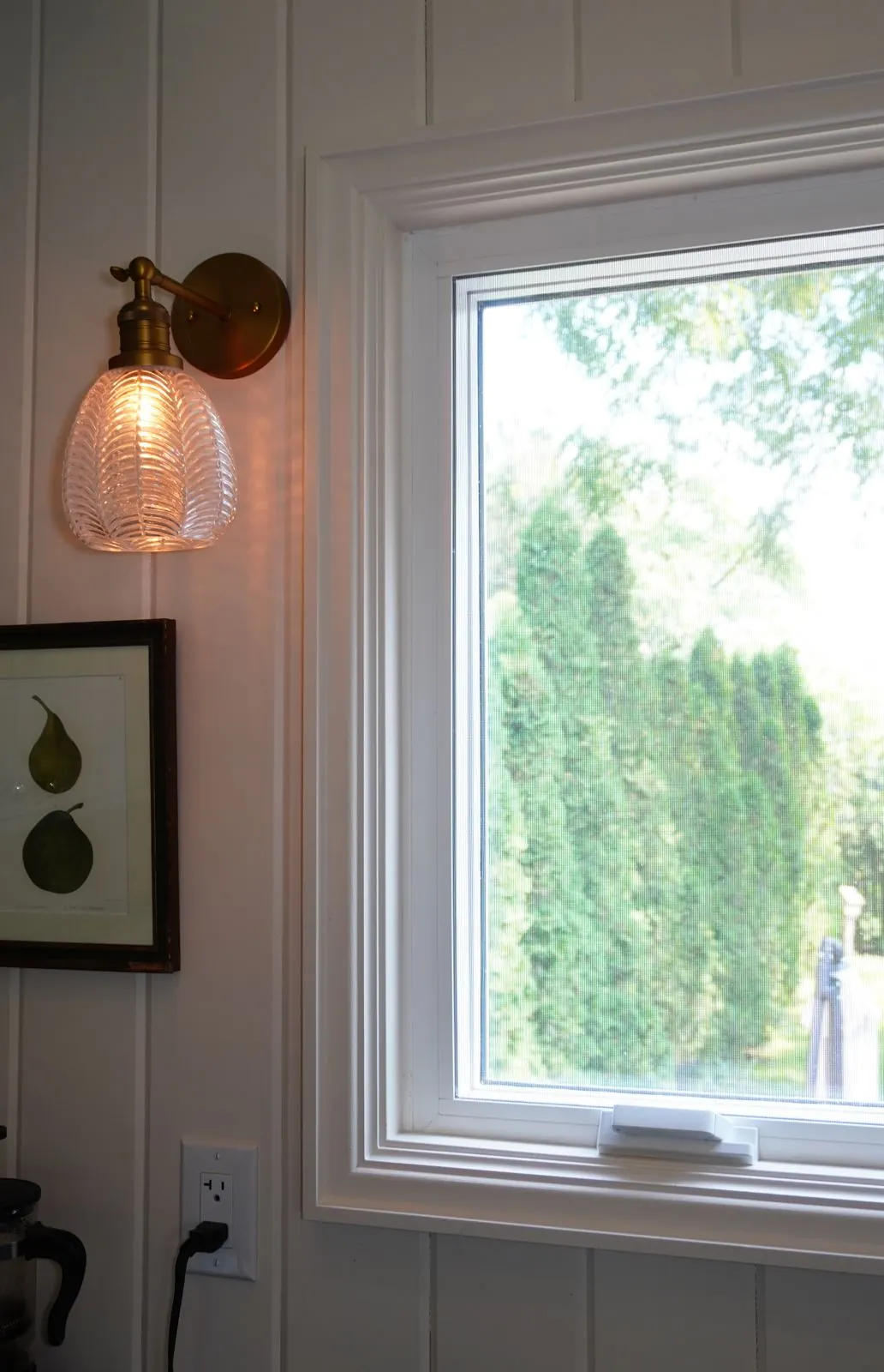 Brass sconce beside a white window
